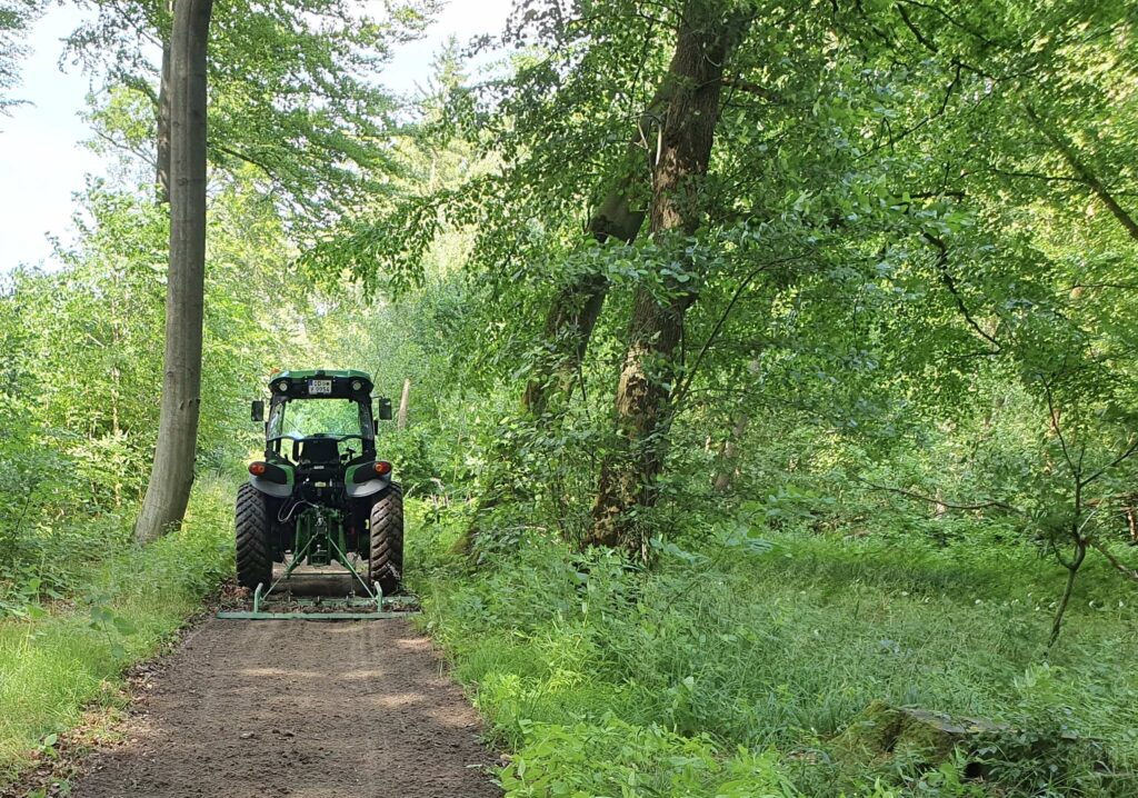 Traktor mit Wiesenschleppe zur Reiwegpflege