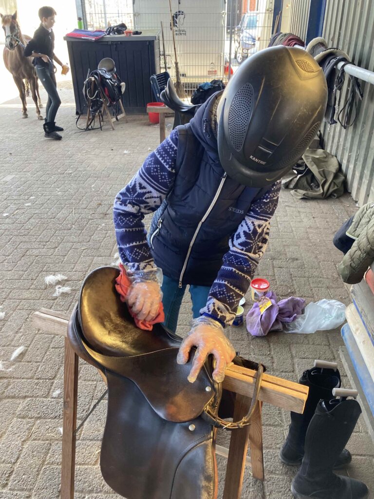 Kinder auf Gut Tangstedt bei der Sattelpflege