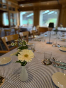 Vase mit frischen Blumen auf einem für eine Feier eingedeckten Tisch