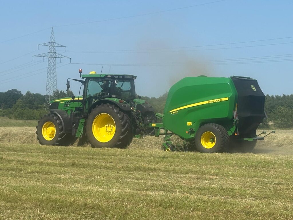 John Deere Traktor und Ballenpresse bei der Ernte auf dem Kringel in Wilstedt