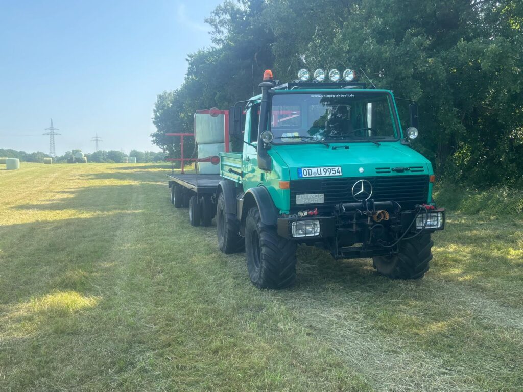 Unimog U1400 fährt Ballen zum Hof