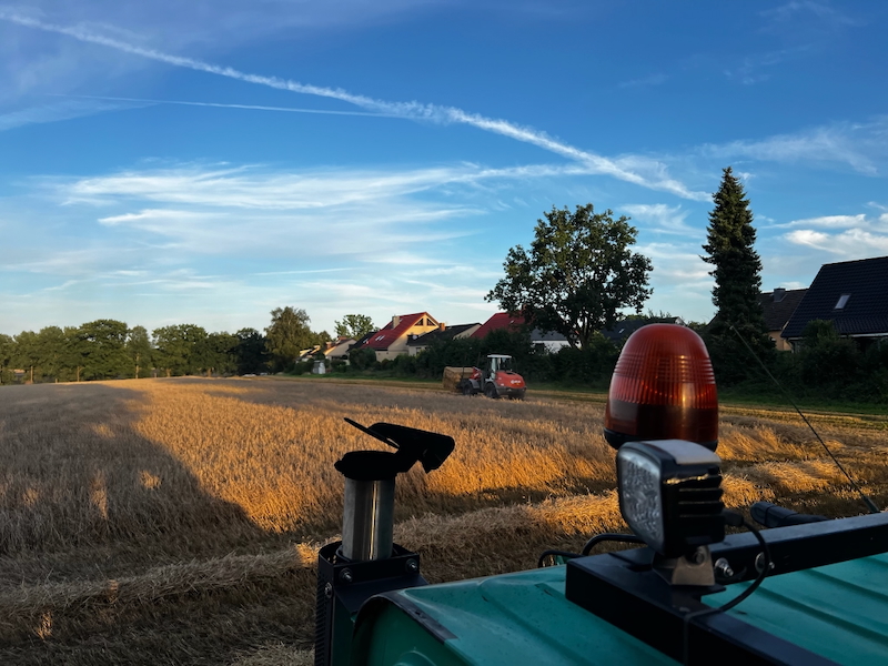 Ballenaufladen während der Strohernte in Tangstedt mit Atlas Radlader im Abendlicht