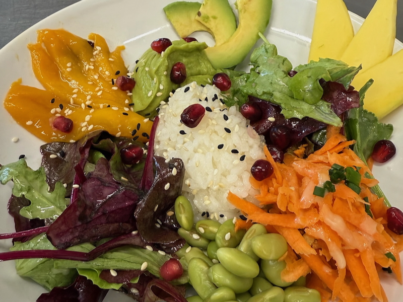 Sushireis angerichtet mit Wildkräutersalat, Möhre, Avocado Tatar, Mango, Edamame, Granatapfelkerne, geröstetem Sesam und einem hausgemachten Limettendressing