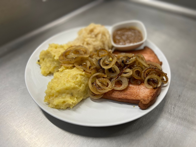 Gebratener Leberkäse mit Speck-Kartoffelstampf, Sauerkraut, gebratenen Zwiebelringen und süßer Senf