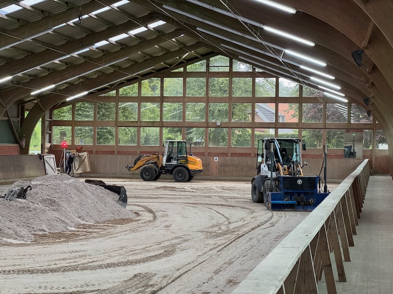 Ueberarbeitung Reitboeden Radlader beim Nivellieren des Reitbodens in Halle 1