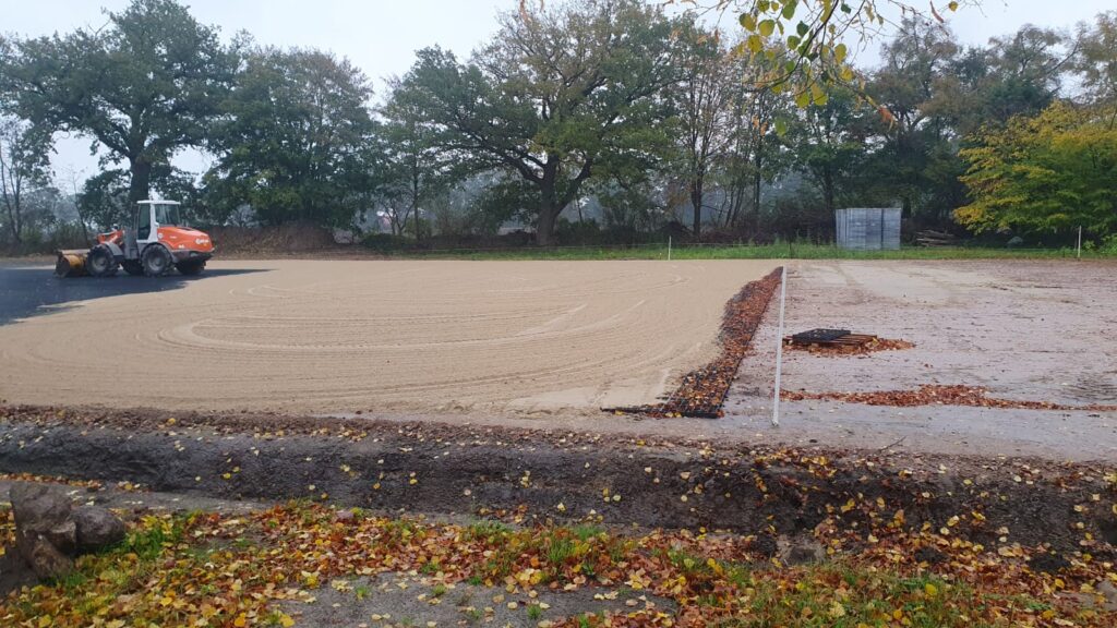 Radlader beim Aufbringen der neuen Tretschicht aus gewaschenem Sand auf den Paddocks von Gut Tangstedt.