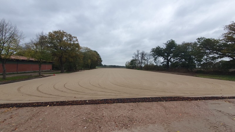 Neue Tretschicht der sanierten Paddocks am Beekmoorweg auf Gut Tangstedt, mit Paddockmatten im Vordergrund und Sandbodenfläche