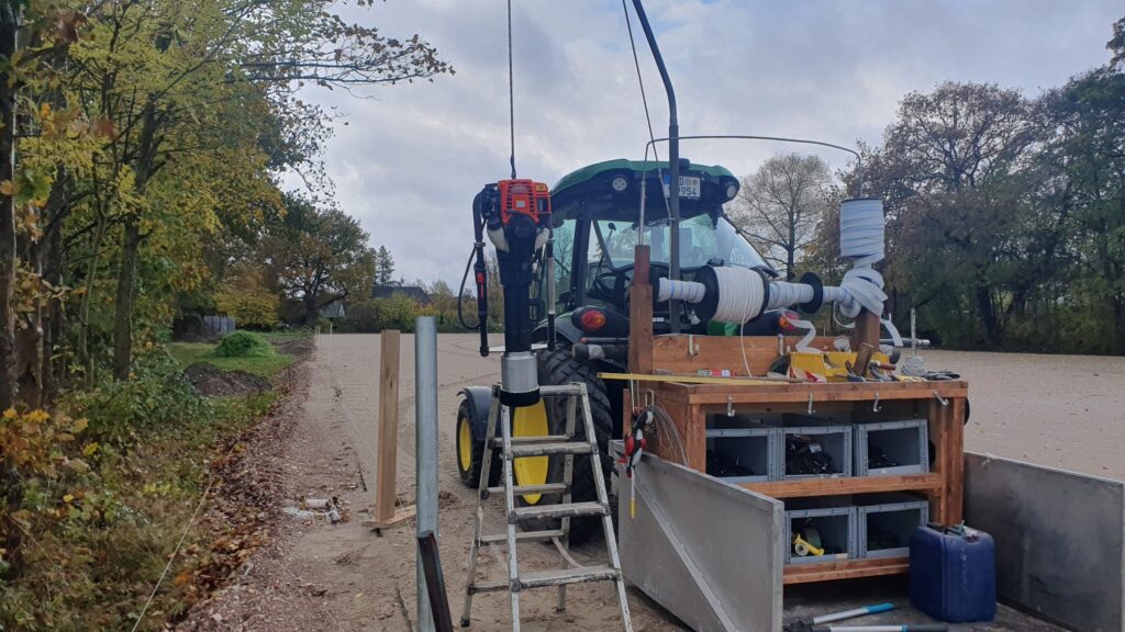 Zaunbau an den neuen Paddocks am Beekmoorweg auf Gut Tangstedt mit Traktor und Pfahlramme während der Arbeiten