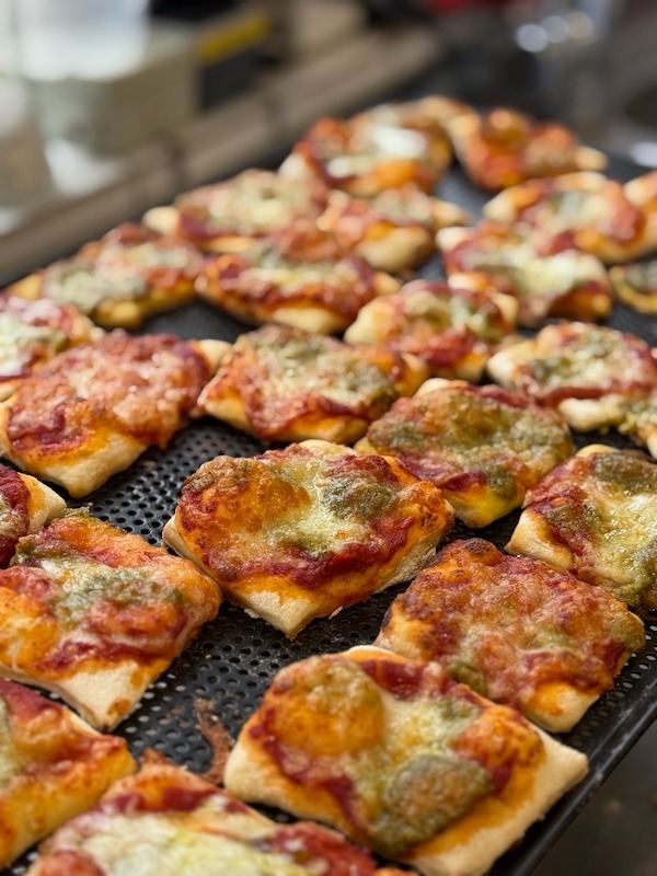 Frisch gebackene Mini-Pizzen mit Tomatensauce, Mozzarella und Pesto – vorbereitet für eine Veranstaltung in der Hofküche Gut Tangstedt