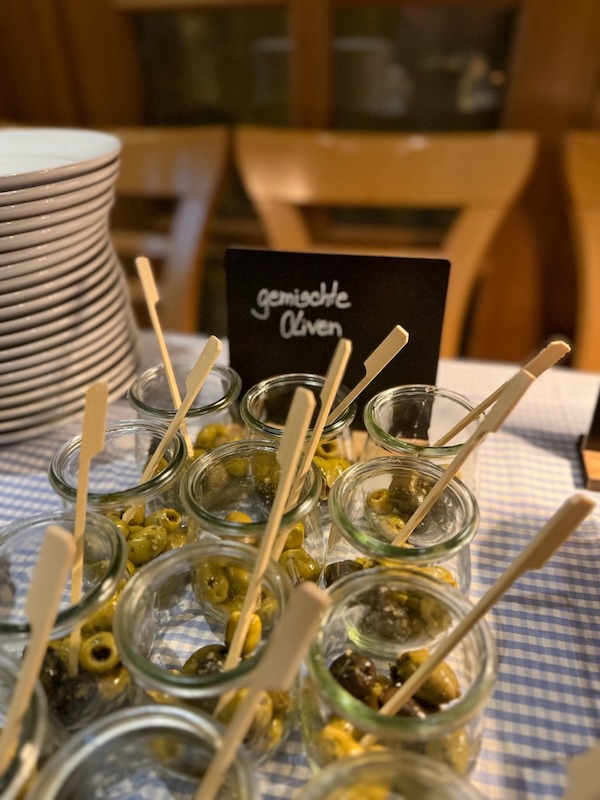Gemischte Oliven im Glas als Teil des Antipasti-Buffets in der Hofküche Gut Tangstedt – mediterrane Vorspeise mit hausgemachtem Charme