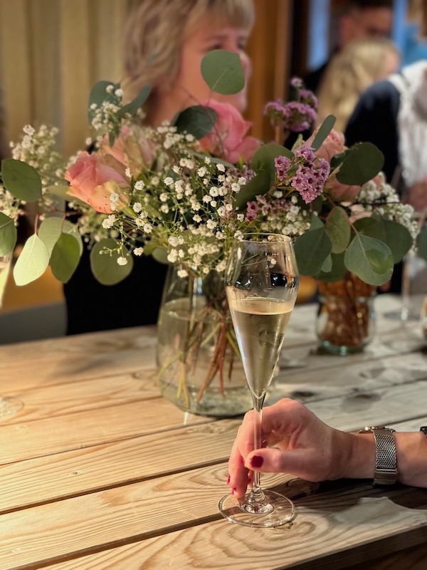 Sektempfang mit Blumenschmuck in der Hofküche Gut Tangstedt – festlich gedeckter Tisch und entspannte Atmosphäre bei einer Feier