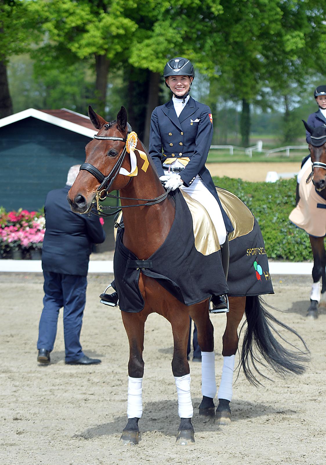 Dressurreiterin Janet Hüttich-Egbers bei der Siegerehrung mit ihrem Pferd im Dressurviereck