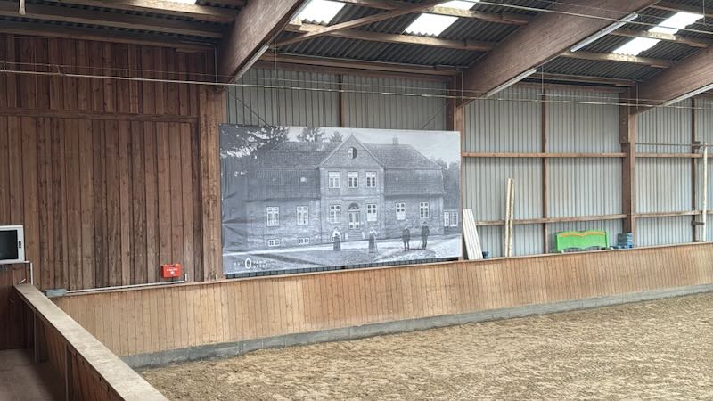 Großformatiges historisches Foto des Kavaliershauses von Gut Tangstedt, montiert an der Bande der Reithalle.