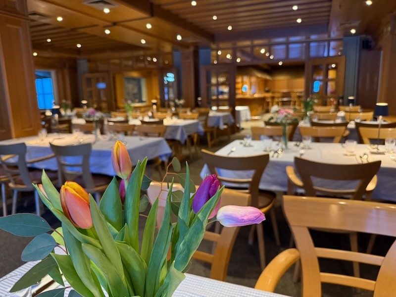 Festlich gedeckte Tische in der gemütlichen Hofküche von Gut Tangstedt mit bunten Tulpen im Vordergrund für einen Geburtstagsbrunch.