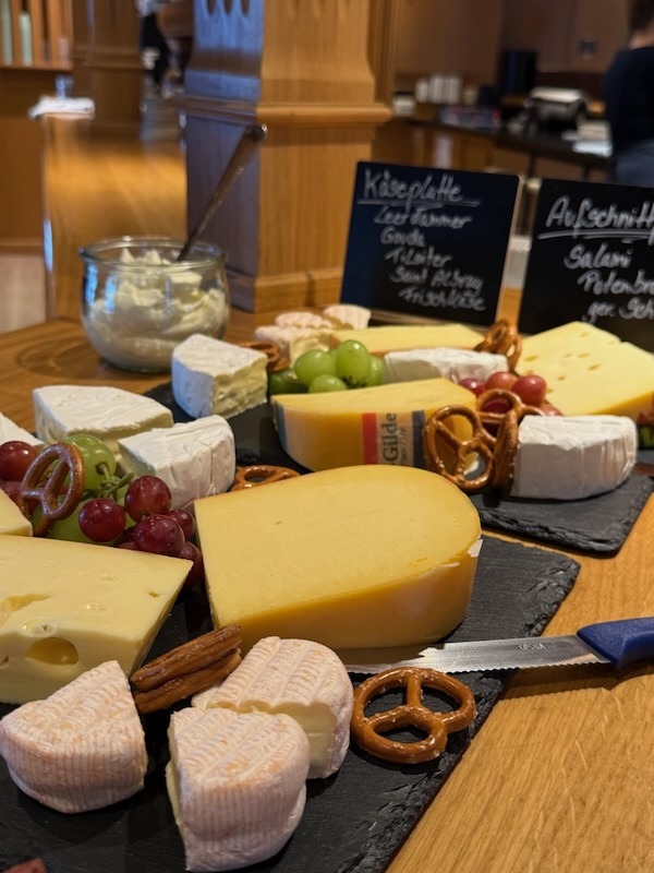 Dekorative Käseplatte mit Camembert, Gouda und Weintrauben, serviert auf Schieferplatten für ein Event-Catering.