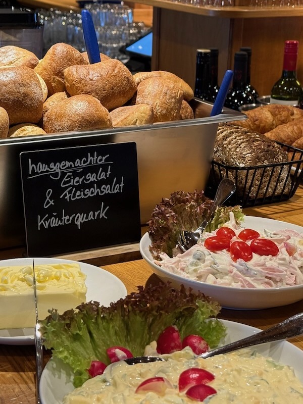 Buffet-Auswahl mit hausgemachtem Eiersalat, Fleischsalat und Kräuterquark, frisch garniert mit Radieschen und Tomaten.
