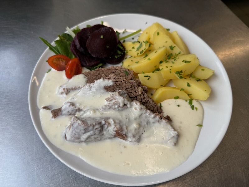 Klassischer Rinderbraten mit einer hellen Meerrettichsauce, serviert mit Salzkartoffeln und einer kleinen Salatgarnitur inklusive Rote Bete.