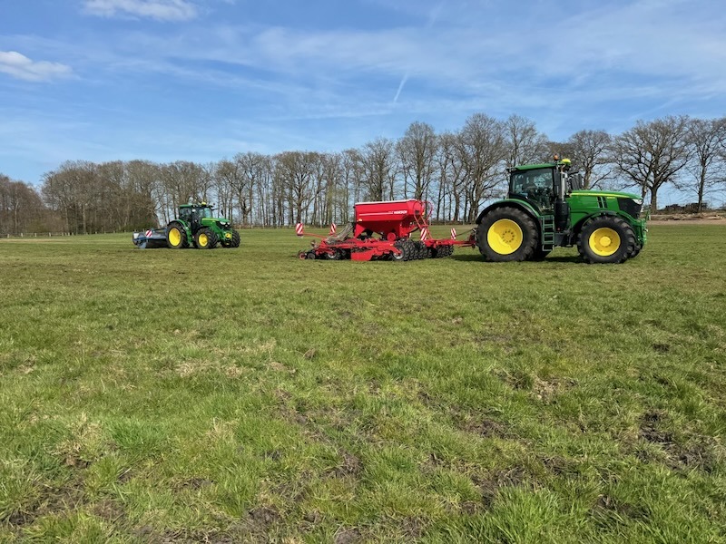 Zwei John-Deere-Traktoren bei der Weidenpflege auf Gut Tangstedt – einer mit Scheibensämaschine beim Nachsäen, einer mit Walze beim Einarbeiten der Saat.
